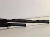rifle on a white table with a black handle and a black barrel