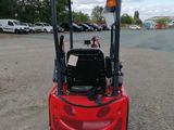 a close up of a red forklift parked in a parking lot