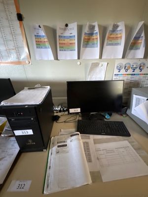 un bureau sur lequel se trouvent un ordinateur, un écran, un clavier et des papiers