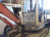 une petite pelleteuse garée dans un garage