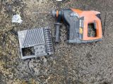 a drill and a charger laying on the ground