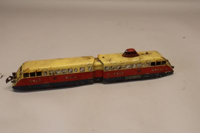 un petit train jaune et rouge posé sur une surface blanche