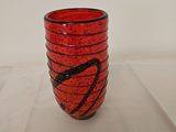 a red glass cup with a black design on it