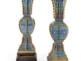 une paire de vases bleus et dorés posés sur un socle en bois