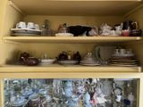 de nombreuses assiettes et tasses sur les étagères de ce placard