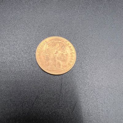 gros plan d'une pièce d'or sur une surface noire