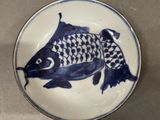 a blue and white plate with a fish design on it