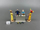 trois figurines représentant des personnes debout devant une table