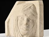 une sculpture représentant le visage d'une femme sur un bloc