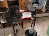 two fans that are sitting on the floor in front of a window