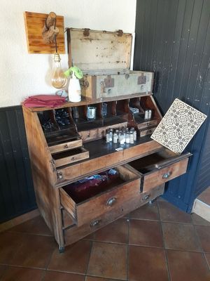 un vieux bureau en bois sur lequel sont posées de nombreuses bouteilles