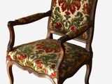 a chair with a floral upholstered back and arms