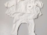 baby clothes on a white table with a tag on it
