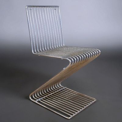 a close up of a metal chair on a gray surface