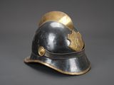 an old helmet with a golden crown on it on a gray background