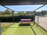 une table de pique-nique rouge posée au milieu d'une pelouse