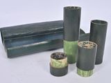 three rolls of black and green paper on a white surface