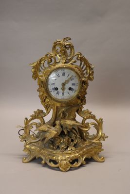 a gold clock sitting on top of a table