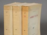 three books sitting on top of each other on a gray surface