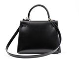 a black handbag with a strap on a white background