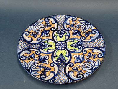 une image représentant une assiette décorative ornée de motifs bleus et jaunes