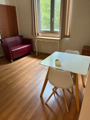 une table et des chaises blanches dans une pièce dotée d'une fenêtre