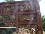 a wooden gate with carvings on it in the woods