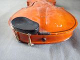 an orange violin case with a black seat on a gray surface