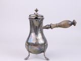 an antique silver coffee pot with a wooden handle on a white background