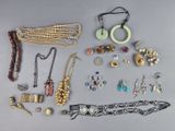 Plusieurs colliers, bracelets et autres bijoux sont disposés sur une table