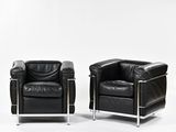 pair of black leather armchairs with chrome legs and arms