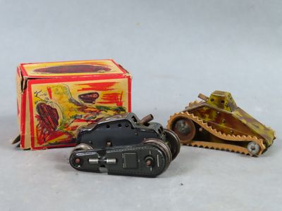 Deux petites voitures jouets sont posées à côté d'une boîte de jouets