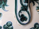 a blue and white vase with a handle on a table