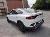 the rear end of a white car parked in a parking lot