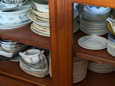 de nombreuses assiettes et bols empilés sur une étagère dans un placard