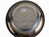 a silver plate on a white surface with a sticker on it