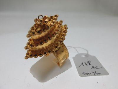 une image d'une bague en or sur une surface blanche avec une étiquette de prix