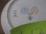 une assiette blanche sur laquelle est collé un autocollant vert