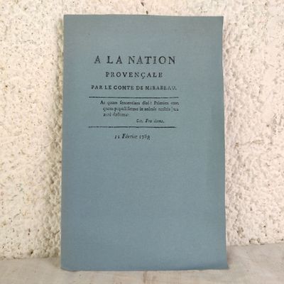 un livre bleu posé sur une table près d'un mur