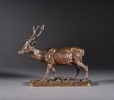 une statue en bronze représentant un cerf, posée sur un socle en bois