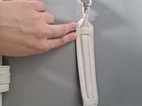 a person holding a white purse with a strap on it