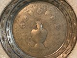 a silver plate with a picture of a bird on it