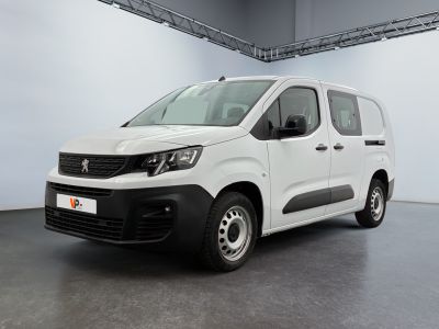 La camionnette blanche est garée dans une grande pièce.