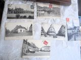 de nombreuses cartes postales anciennes posées sur une table sur laquelle se trouve une horloge