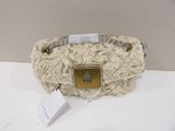 beige and white purse with a gold buckle on a white table