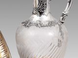 deux vases en argent et en verre et un plateau en argent posé sur un socle