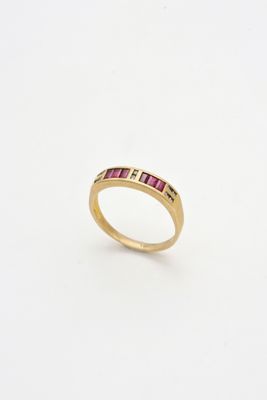 une bague en or sertie de pierres roses sur fond blanc