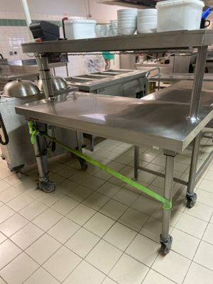a large stainless steel table in the middle of a kitchen