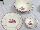 three pieces of red and white dinnerware on a table