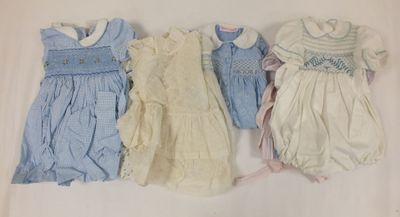 trois vêtements pour bébé sont alignés sur une surface blanche